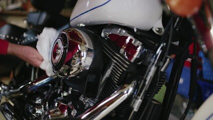 Workshop repair man cleans a beautiful and shiny classic motorbike in garage