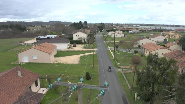 Motorcycle drives through France countryside on a cloudy autumn day, drone dolly