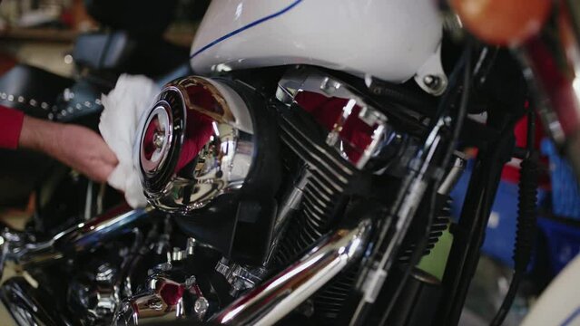 Workshop repair man cleans a beautiful and shiny classic motorbike in garage