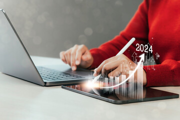 Businesswoman analyzing market goals in 2024 with company profitability at work Global companies Digital market infographic, positive indicator for 2024, businessman calculates financial data for long - obrazy, fototapety, plakaty