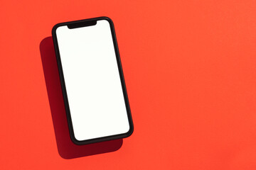 Smart phone mockup on red background, floating, high angle view
