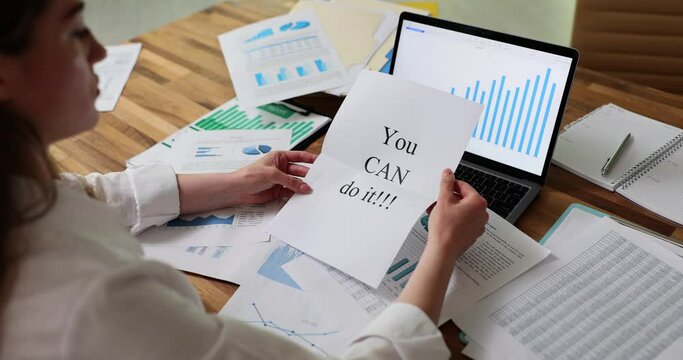 Woman at table with papers opening letter with inscription you can do it 4k movie. Motivation and striving for better work concept