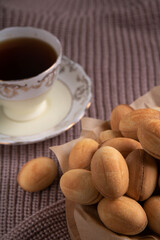 Photography showcases a delicious dessert scene. Homemade cookies, drizzled with sweet condensed milk, sit on a warm sweater background.