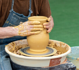 Clay craftsman sculpts crockery . Close-up.
