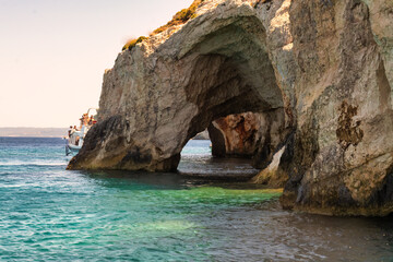 Boat going through the blue caves in Zakynthos island in Greece.
 - Powered by Adobe