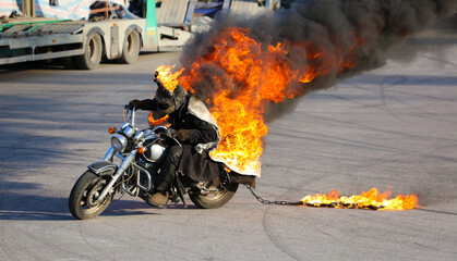 The motorcycle rides in flames of fire on the road
