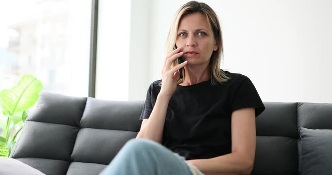 Woman talking on mobile phone and looking at camera suspiciously 4k movie slow motion. Spy apps for mobile phones tracking concept 