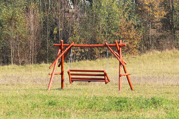 Obraz na płótnie Canvas Plastic seat of a children's chain swing suspended above the earth. Adaptations for a playground. Memories of a joyful and carefree life. Use a metal chain. Activity of the growing up generation