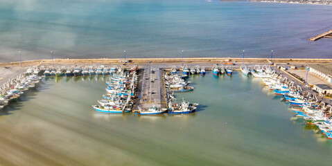 Fishing boats in the port of Mazara del Vallo in Sicily, aerial overhead view from drone.