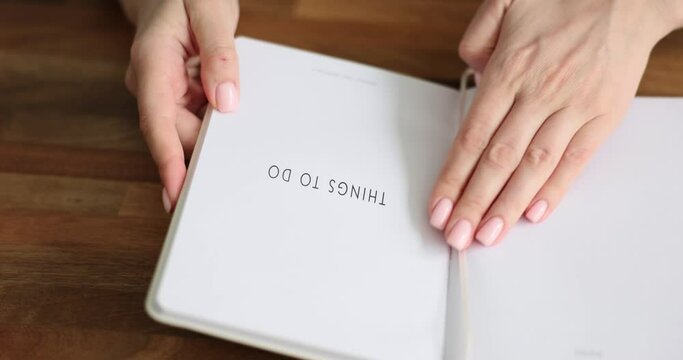 Female hands opening notepad with inscription things to do closeup 4k movie. Planning goals and objectives concept