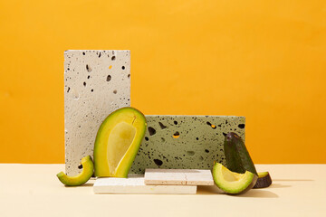 Minimalist background for presentation cosmetics with avocado extract. Fresh slices of avocado and...