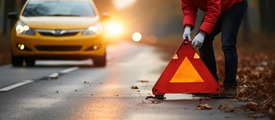 Fotobehang Man standing on the road with red warning triangle. Road safety concept © afzar
