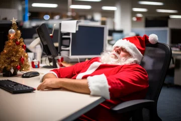 Foto op Canvas Santa is tired at the office, after preparing all the online orders. a man in a santa claus costume laying oncomputer desk ,Christmas concept © XC Stock