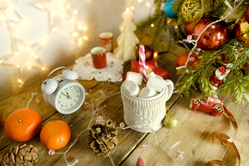 beautiful holiday composition with decorated New Year's tree, garlands, lights, candles, mug of hot cocoa with marshmallows, New Year Atmosphere, Winter Holiday Vibes