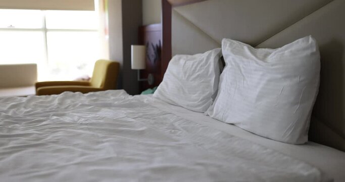 White cotton bed linen on hotel bed 4k movie. Comfort at home concept