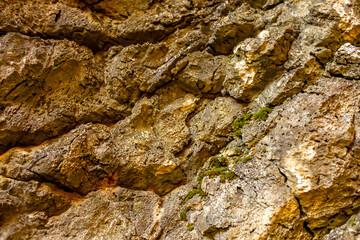 Natural rock texture background. Rocky bas-relief wall.
