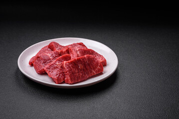 Fresh juicy raw beef slices with salt and spices