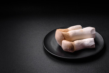 Pleurotus eryngii mushrooms on a dark concrete background
