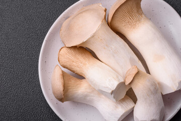 Pleurotus eryngii mushrooms on a dark concrete background