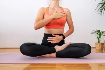 Poster Im Rahmen Meditation breathing exercise. Female person wearing sportswear sitting in lotus yoga pose and meditating. © Barillo_Picture