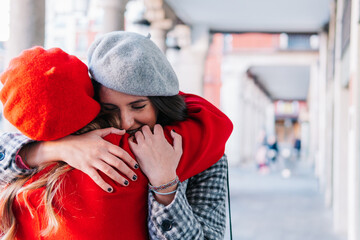 Two friends hug each other excitedly at a meeting on the street. Return home for Christmas.