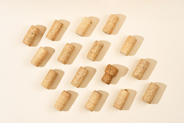 Pattern with wine and champagne corks, sun glare from a champagne bottle on a beige background with hard sunlight and shadow.