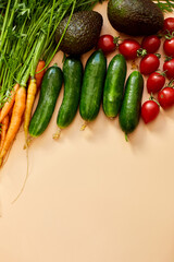 Flat lay vegetables, carrots, cucumbers, avocados, tomatoes on the biege background, grocery concept, Healthy food