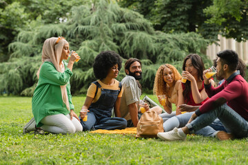 Group of happy diverse multiracial generation z young people at outdoor party drinking and talking...