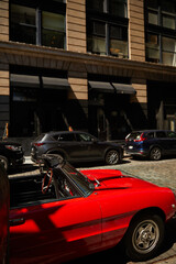 red vintage car and other vehicles parked near building on street in new york city, urban scene
