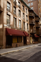 low story stone building with balconies on narrow and cozy street, new york city architecture