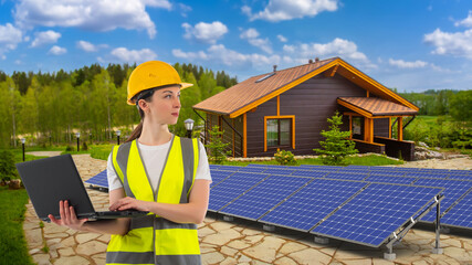 Solar energy. Woman builder with laptop. Girl works in energy industry. Engineer near cottage with solar panels. Home with photovoltaic generators. Woman adjusts solar panels. Energy efficient house