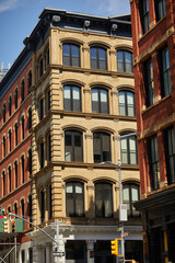 Fototapeta premium corner of vintage building with arch windows near traffic lights in downtown of new york city