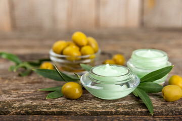 Jar of natural olive cream with olive oil extract on a texture background. Cosmetic tube. Moisturizing cosmetic cream for skin. Body care. Beauty concept. Copy space. Flat lay. Hand cream.