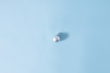Minimal Christmas decoration with a silver bauble. Holiday concept. Flat lay.