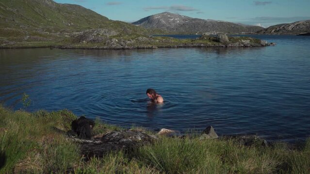 A Person Is Bathing In Botnvatnet Lake In Nordland, Norway. Static Shot