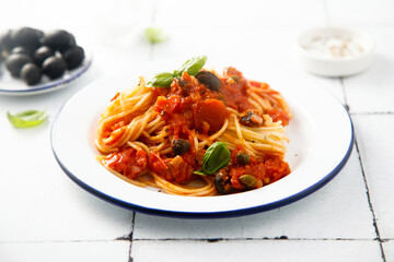 Traditional pasta with tomatoes, olives and anchovy