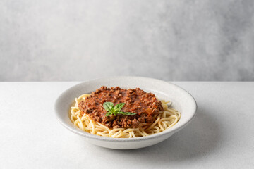 Side view of pasta with bolognese meat sauce. Fresh Pasta on white table with copy space