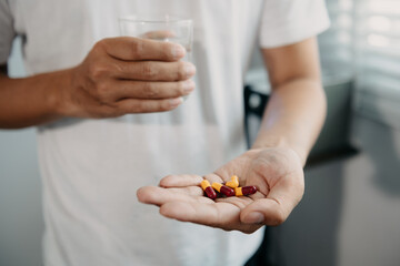 pills in a Senior's hands. Painful yound age. Caring for the health of the elderly