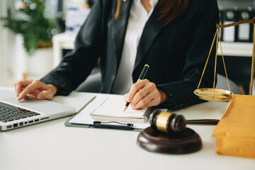 justice and law concept. asian woman lawyer working and judge in a courtroom the gavel, working with tablet and laptop and digital tablet computer