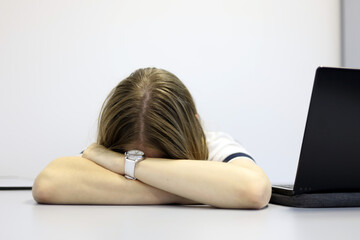 Girl sleeping near the laptop at office table. Concept of overworked employee, tired after work,...