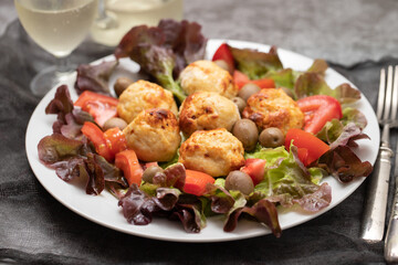 Chicken meatballs on lettuce with tomato and olives