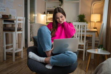 Fototapeta premium One young woman use laptop computer at home while sit comfortable