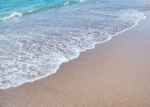 Soft wave of blue sea on sandy beach.