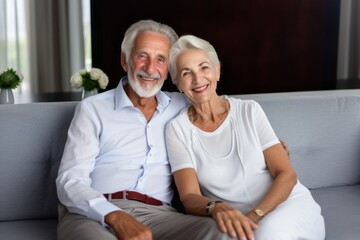 sweet old adult retired couple people stay home sit relax positive conversation on sofa couch in living room home interior background