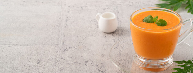 Delicious papaya milk smoothie in glass cup on gray table background