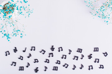 Conceptual background of black musical notes and dried flowers top view