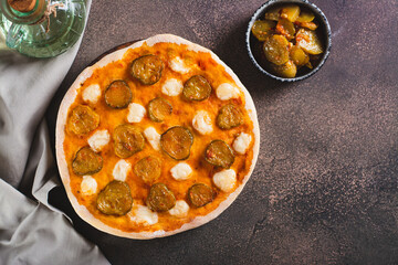 Pizza with pickles and mozzarella on a wooden board on the table top view
