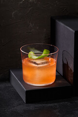 A contemporary gin and tonic infused with bergamot, elegantly set on podiums, exuding minimalist design against a stark black backdrop