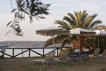 Retro style sun chairs and parasol in the tropical garden with a seaview © triocean