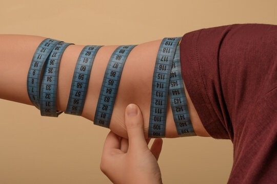 Kobieta mierzy obw&oacute;d ramion, brak mięśni i obwisła sk&oacute;ra 